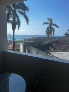 a view of the ocean from a balcony with palm trees at Sunny Tides at Montego Bay Club Resort in Montego Bay