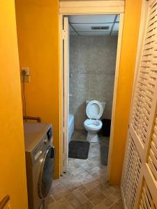 uma casa de banho com um WC e uma máquina de lavar roupa em Sunny Tides at Montego Bay Club Resort em Montego Bay