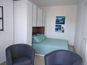 - une chambre avec un lit et deux chaises dans l'établissement Lovely 1-bedroom Vacation Home With Gorgeous Views, à Mellieħa