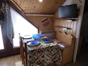 a table in a tiny house with a tv at Résidence Combettes - 2 Pièces pour 4 Personnes 624 in Les Contamines-Montjoie