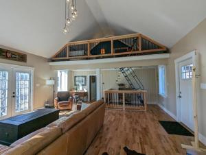 ein Wohnzimmer mit einem Sofa und einer Treppe in der Unterkunft Newmont Lodge in Hoosick Falls