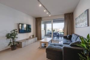 a living room with a couch and a table at 9ten11 Seafront in Mellieħa