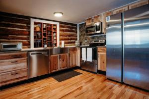 een keuken met roestvrijstalen apparatuur en houten kasten bij Newmont Lodge in Hoosick Falls