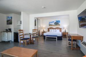 ein Schlafzimmer mit einem Bett und einem Tisch und Stühlen in der Unterkunft Solvang Inn & Cottages in Solvang + 29 Fotos
