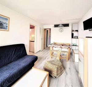 una sala de estar con un sofá y una mesa en Résidence Phenix - STUDIO CABINE 4/5 PERSONNES MAE-9734, en Le Corbier