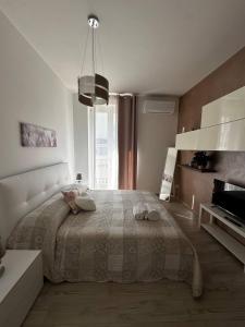 a white bedroom with a large bed and a window at Bella Puglia Bed and Breakfast in Ruvo di Puglia