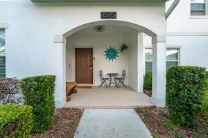 a front porch of a white house with a table and chairs at New - Champions Gate 5-Bedroom in Davenport