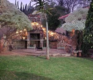 a stone house with chairs and a table in a yard at 66 Sharalumbi Wildlife Estate in Lydenburg