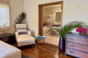 1 dormitorio con silla, tocador y espejo en Stunning 1 Bedroom Hideaway Palm / Garden View, en Gaynors