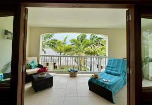 a living room with a blue chair and a window at Stunning 1 Bedroom Hideaway Palm / Garden View in Gaynors