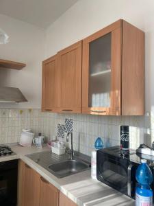 una cocina con fregadero y armarios de madera en Appartamento ampio ed indipendente, en Formigliana