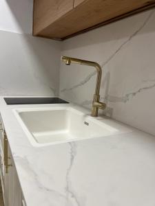 a kitchen sink with a gold faucet on a counter at מול הים בקיסריה in Caesarea