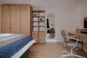 een slaapkamer met een bed, een bureau en een stoel bij Ferienwohnung am Kirchbrunnen in der Rhön, pure Erholung in traumhafte Betten! in Urspringen