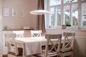 een eetkamer met een tafel en stoelen en een raam bij Ferienwohnung am Kirchbrunnen in der Rhön, pure Erholung in traumhafte Betten! in Urspringen