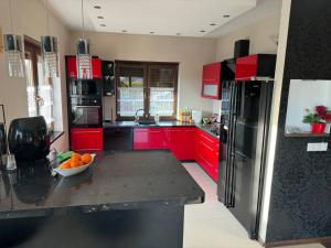 una cocina con armarios rojos y un bol de fruta en una barra en Dom Krotoszyce, en Krotoszyce