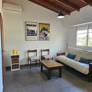 uma sala de estar com um sofá e uma mesa em Jacarandá, amplio departamento con terraza em Chascomús