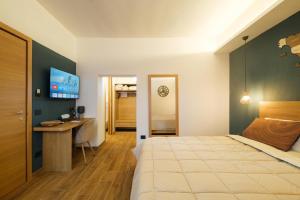 a bedroom with a bed and a desk in it at In centro da Carlotta in Olbia