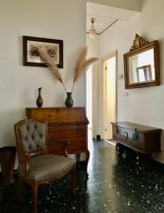a room with a piano and a chair and a mirror at Casa Vintage in Alassio