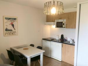 a small kitchen with a small table and a small kitchen with a table and chairs at Résidence Hameau De Balestas Mp - 2 Pièces pour 4 Personnes 924 in Germ