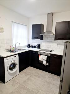 a kitchen with a washing machine and a sink at Fantastic Home! Football Fans -5 min to Stadium in Liverpool