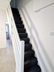 a black staircase with white railings in a house at Fantastic Home! Football Fans -5 min to Stadium in Liverpool
