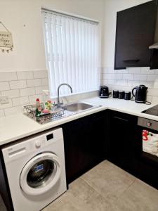 a kitchen with a washing machine and a sink at Fantastic Home! Football Fans -5 min to Stadium in Liverpool