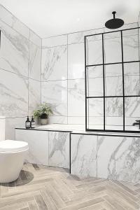 a white bathroom with a sink and a toilet at Newly refurbished home on the North Coast - AONB in Bushmills
