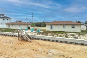 a house in the sand next to a house at Quarter Deck Cottage on Flagler Beach in Flagler Beach