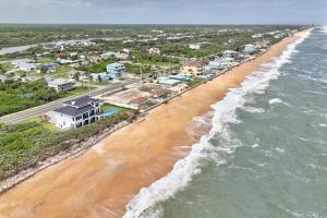 una vista aerea di una spiaggia con case e l'oceano di Quarter Deck N | Flagler Beach a Flagler Beach