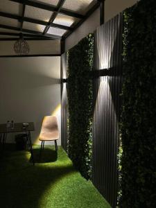 a chair sitting in a room with a green wall at Eco-friendly studio close to all services in Riyadh