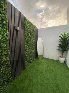 a garden with a plant and a surfboard on a wall at Eco-friendly studio close to all services in Riyadh
