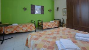 um quarto com duas camas e paredes verdes em Il Lato Azzurro em Veneza