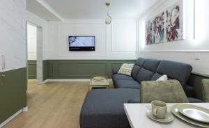 a living room with a couch and a tv at Imedio Olive Apartment Aviatiei in Bucharest