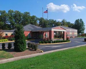 a building with an american flag on top of it at SureStay Plus by Best Western Corydon in Corydon