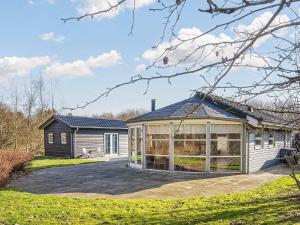a house with a large glass greenhouse in the yard at 4 star holiday home in Ansager-By Traum in Ansager