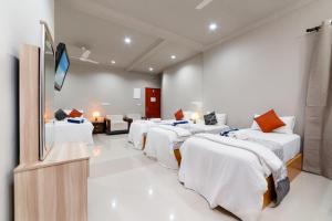 烏庫哈斯的住宿－Palm Oasis at Ukulhas，客房设有几张床和一台平面电视。