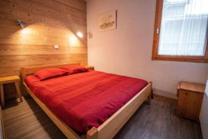 sypialnia z dużym łóżkiem i czerwonym kocem w obiekcie MUCILLON G - Appartement MUCILLON 21 pour 6 Personnes 99 w mieście Valmorel