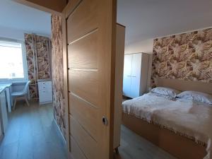 Un dormitorio con una cama y un gran armario de madera. en Apartament w Srebrnym Mieście en Tarnowskie Góry