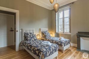 a bedroom with two beds and a fireplace at Villa du Lys in Luchon