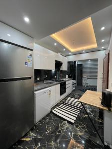a kitchen with white cabinets and a stainless steel refrigerator at Stay in the heart of the city in Istanbul
