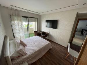 um quarto com uma cama, uma janela e uma mesa em Luxueux appart à côté aéroport em Nouaceur