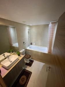 a bathroom with a sink and a bath tub at Luxueux appart à côté aéroport in Nouaceur