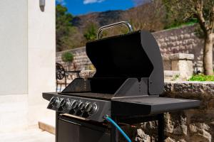 einem schwarzen Grill neben einer Wand in der Unterkunft Majestic Apartment in Tivat