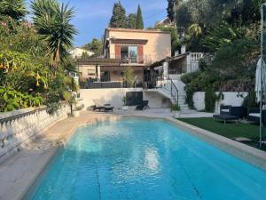 a swimming pool in front of a house at Rez de villa avec piscine in Menton