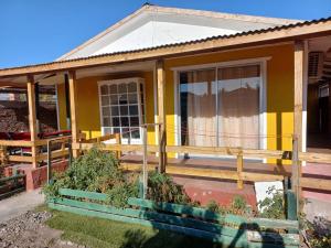 a small yellow house with a porch at Casa Lo Herrera in Isla de Maipo