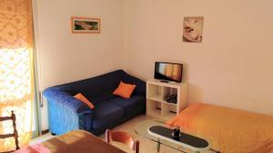 un soggiorno con divano blu e TV di Very nice Apartment Padova Centre a Padova