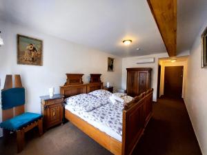een slaapkamer met een bed en een blauwe stoel bij Hotel u Jindry in Železnice