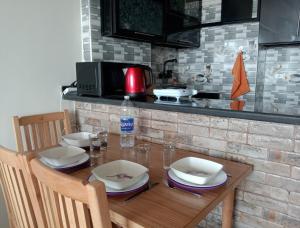 a wooden table with chairs and plates and a microwave at Giza Pyramids View Apartment in Cairo