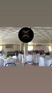 a room filled with white tables and white chairs at Hotel COSTAS in Fortuna