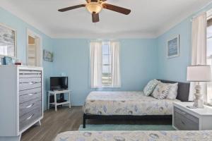 a bedroom with a bed and a ceiling fan at Quarter Deck Cottage on Flagler Beach in Flagler Beach